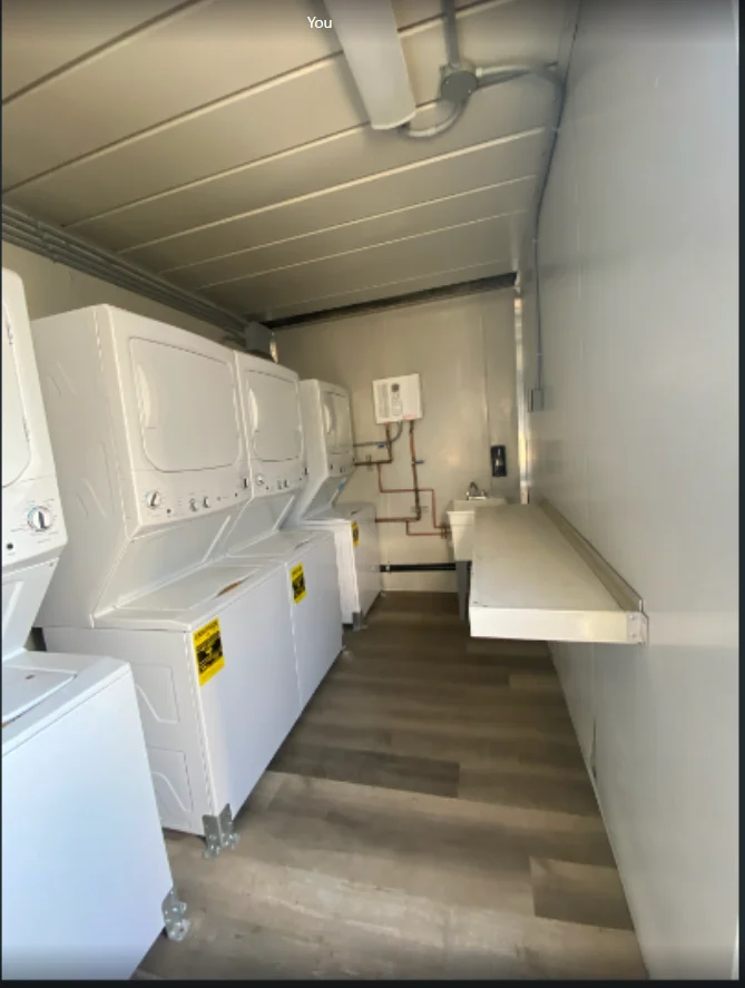 Laundry-container interior with stacked machines and a folding table